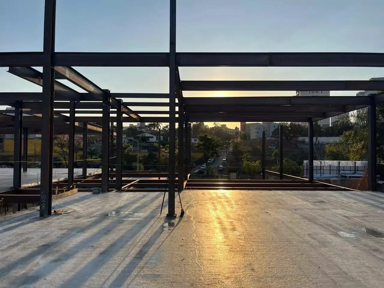 Estrutura metálica montada no alto de um edifício, ao pôr do sol