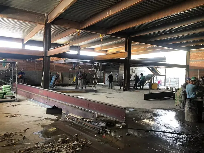 Viga metálica sendo posicionada no piso da obra